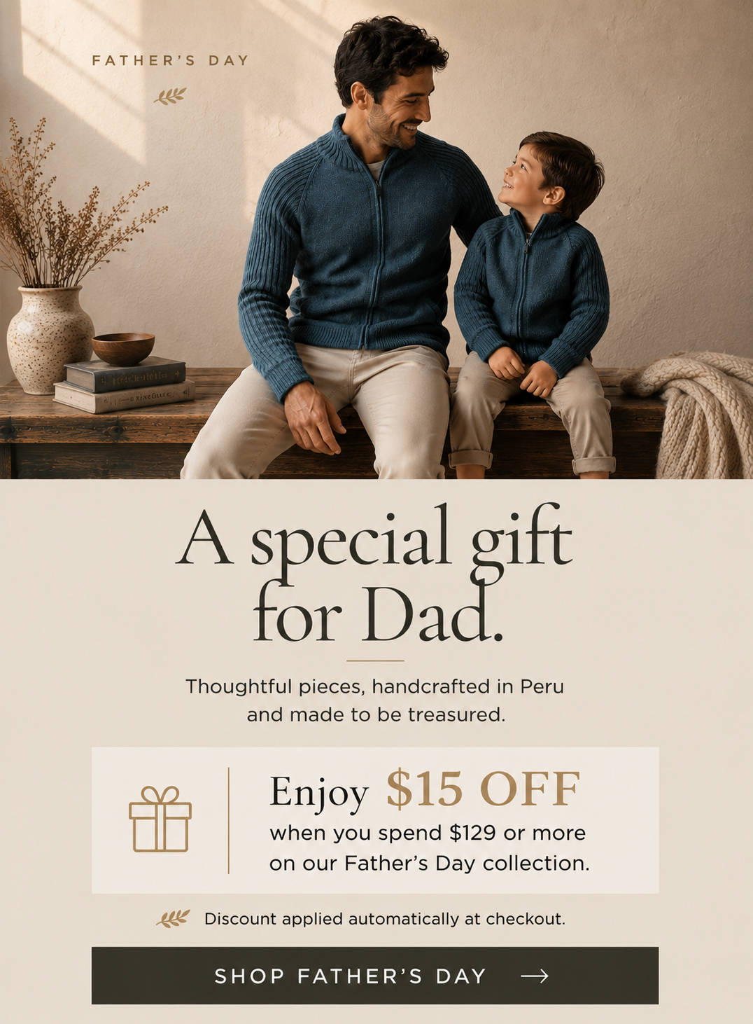 A Father's Day promotional banner featuring a man and a child wearing matching navy blue quarter-zip knit sweaters, sitting together on a wooden bench in a warm indoor setting. Below the photo, the text reads 'A special gift for Dad.