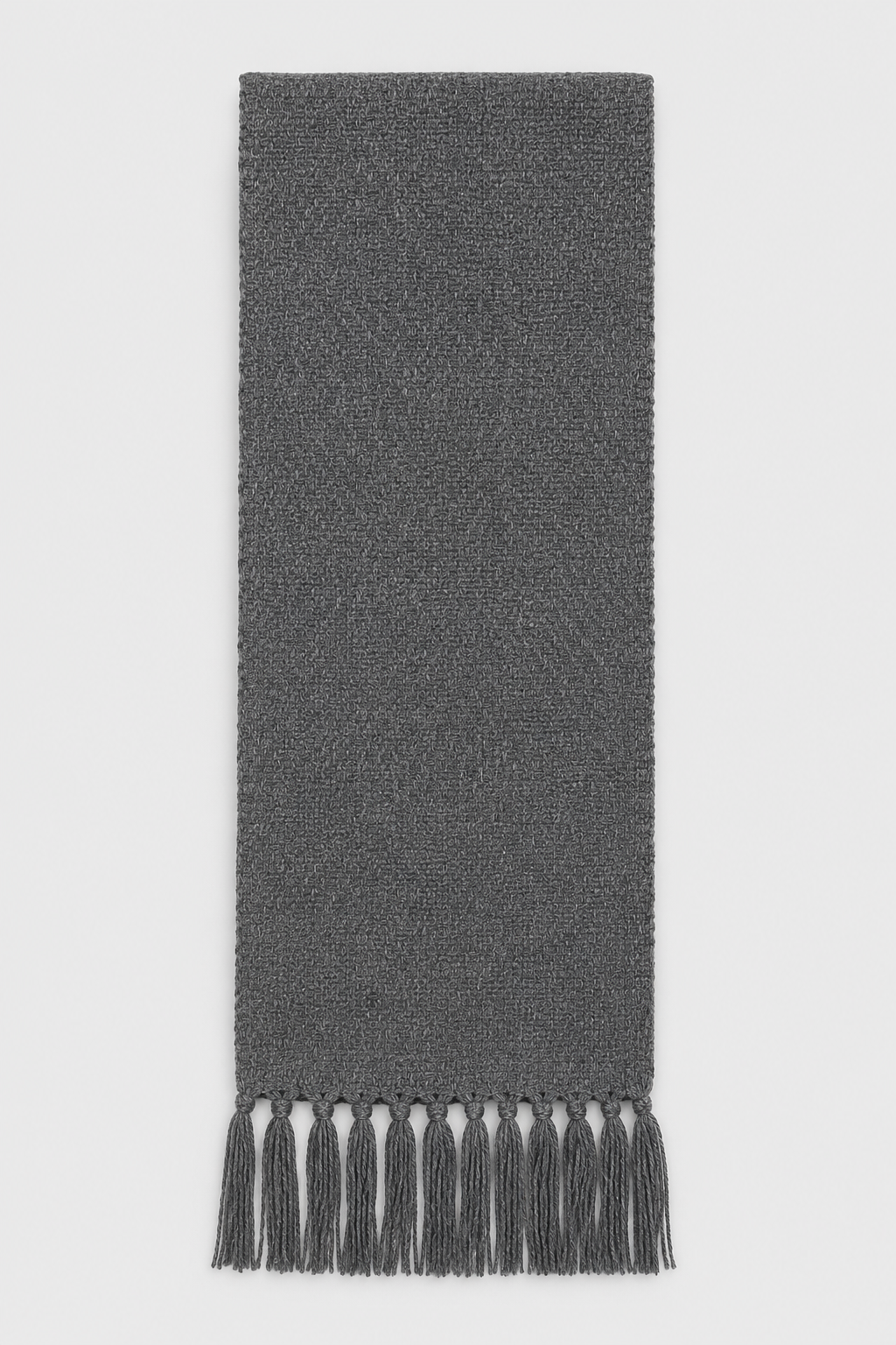 A dark gray woven scarf with fringed tassels at the bottom, shown flat against a light gray background.